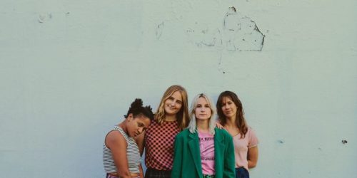 The Buoys band in front of light blue wall